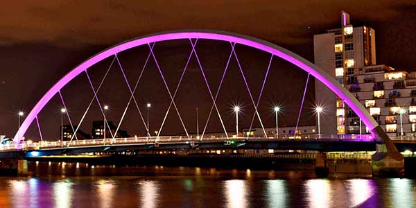 Clyde arc bridge lit up purple at night.