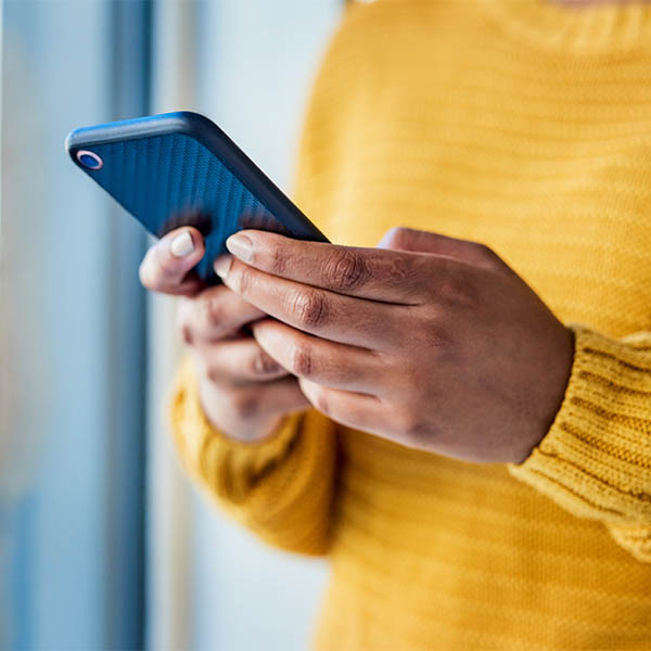 Close up of someone's hands as they use a mobile phone.